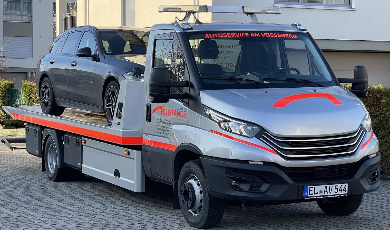 Silberner Abschleppwagen von Autoservice am Vosseberg mit geladenem Kombi