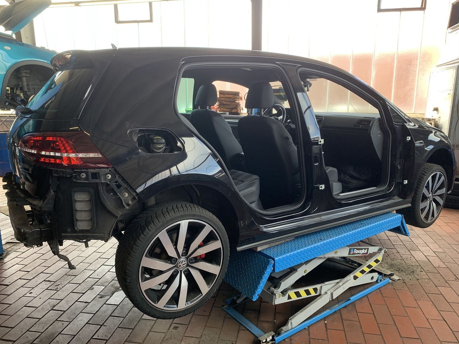 Golf ohne Türen auf der Hebebühne in der Werkstatt
