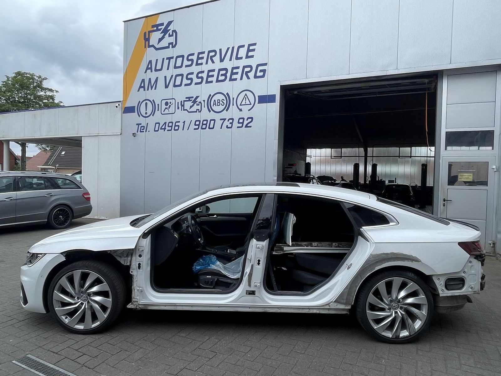 Weißes Coupé in der Instandsetzung vor der Werkstatt am Vosseberg